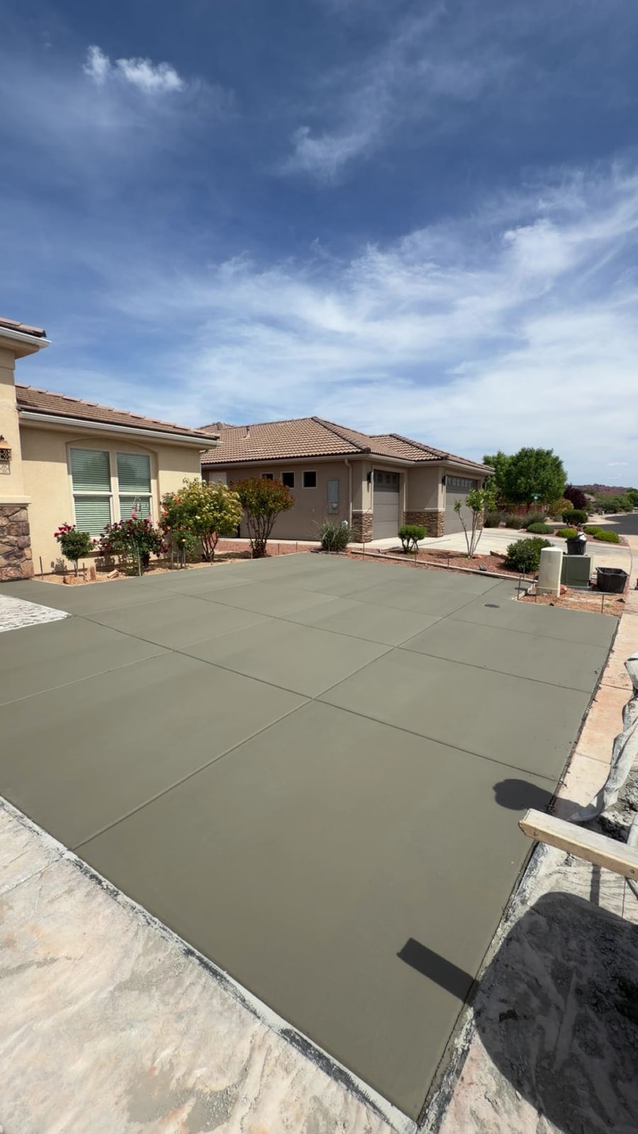 Freshly poured concrete driveway with control joints and perimeter forms