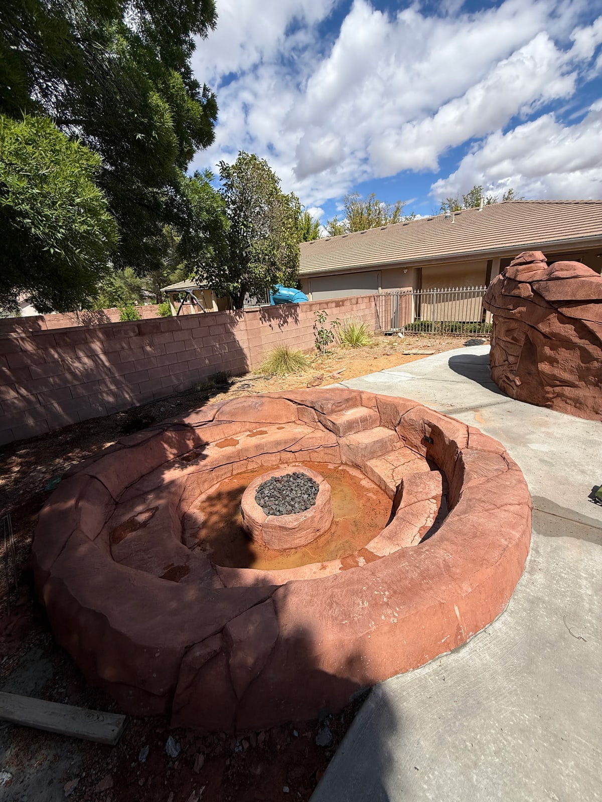 Circular rock-style seating around a central fire feature